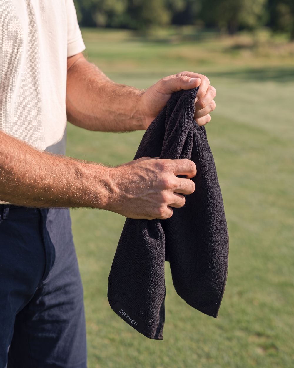 Golfer drying his hands on the terry face, towel off the bag