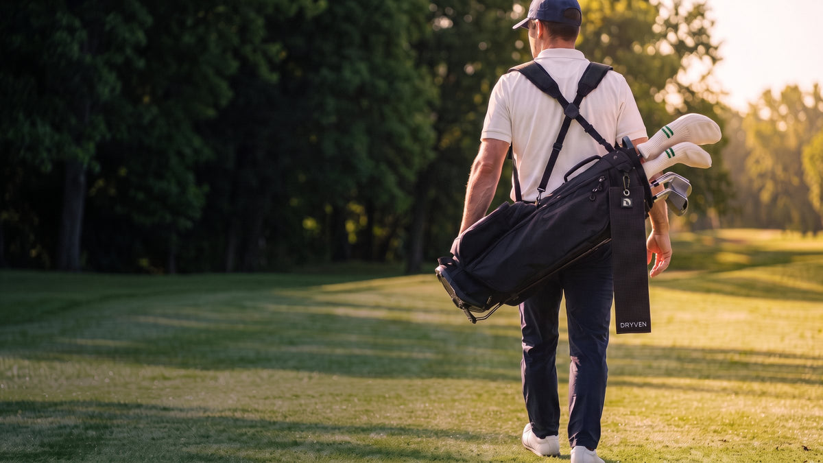 Golfer walking the fairway with a stand bag on his back and the black Dryven towel clipped to it